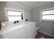 Bright laundry room features washer and dryer, tile floors and light blue walls at 11 Lafayette St, Bradenton, FL 34208
