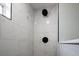 Shower with white marble tiles and black fixtures at 11 Lafayette St, Bradenton, FL 34208