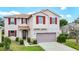 Charming two-story home with red shutters, a well-manicured lawn, and a two-car garage at 1105 Canyon Oaks Dr, Brandon, FL 33510