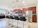 Modern kitchen features a breakfast bar with seating, granite counters, stainless steel appliances, and pendant lighting at 1105 Canyon Oaks Dr, Brandon, FL 33510
