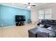 The living room features neutral tile floors, a blue accent wall, large window, and comfortable black leather sofa at 1105 Canyon Oaks Dr, Brandon, FL 33510