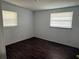 Bright bedroom with two windows, wood-look floors, and fresh paint at 1204 E Camellia Dr, Brandon, FL 33510