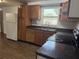 Functional kitchen featuring wood cabinets, a double basin sink, and sleek black countertops at 1204 E Camellia Dr, Brandon, FL 33510