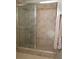 Bathroom shower with sliding doors, neutral-tone tiles, and a mounted shower head at 12121 Wildbrook Dr, Riverview, FL 33569