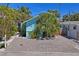 Charming blue home with lush tropical landscaping and a brick paver driveway at 13123 4Th E St, Madeira Beach, FL 33708