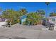 Charming, light blue home with tropical landscaping and a brick driveway at 13123 4Th E St, Madeira Beach, FL 33708