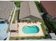 Aerial view of a private backyard oasis featuring a sparkling pool, patio seating, and well-maintained landscaping at 1666 Meadow Oak Ln, Tarpon Springs, FL 34689