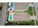 This aerial view captures a home with a well-maintained roof, lush lawn, and a beautiful private pool at 1666 Meadow Oak Ln, Tarpon Springs, FL 34689