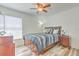 Comfortable bedroom with a ceiling fan, wood-look floors, and natural light at 1666 Meadow Oak Ln, Tarpon Springs, FL 34689