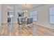 Dining area featuring a modern glass table and wood-look tile floors, conveniently located near the kitchen at 1666 Meadow Oak Ln, Tarpon Springs, FL 34689