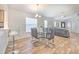 Bright dining area with a glass table, wood-look tile floors, and open flow to the living room at 1666 Meadow Oak Ln, Tarpon Springs, FL 34689