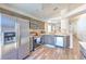 Modern kitchen with stainless steel appliances, wood-look floors, and view to dining area at 1666 Meadow Oak Ln, Tarpon Springs, FL 34689