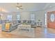 Inviting living room with a comfortable gray sectional, wood-look tile floors, and lots of natural light at 1666 Meadow Oak Ln, Tarpon Springs, FL 34689