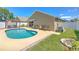Backyard pool featuring a concrete deck, awning, and patio seating in a fenced yard at 1666 Meadow Oak Ln, Tarpon Springs, FL 34689
