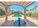 Backyard oasis with a pool, covered pergola, lounge chairs, and privacy fencing at 1666 Meadow Oak Ln, Tarpon Springs, FL 34689