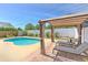 Backyard oasis featuring a pool, covered pergola, lounge chairs, and privacy fencing at 1666 Meadow Oak Ln, Tarpon Springs, FL 34689