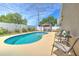 Residential backyard showcasing an in-ground swimming pool and comfortable patio seating under a pergola at 1666 Meadow Oak Ln, Tarpon Springs, FL 34689