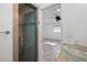 Bathroom featuring a glass shower with pebble flooring and neutral tiles plus a view of the bedroom at 1720 Emerald Dr, Clearwater, FL 33756
