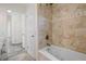 Bathroom with tiled shower/tub combo and a jacuzzi tub with neutral walls, tile floors, and decor at 1720 Emerald Dr, Clearwater, FL 33756