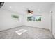 Bright bedroom featuring neutral walls and tile floors, windows, and a ceiling fan with lights at 1720 Emerald Dr, Clearwater, FL 33756