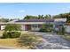 Charming ranch-style home with a brick facade, mature landscaping, and solar panels on the roof at 1720 Emerald Dr, Clearwater, FL 33756