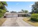 Charming single-story home featuring a two-car garage, solar panels, and a spacious driveway at 1720 Emerald Dr, Clearwater, FL 33756