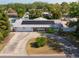 Spacious single-story home featuring a circular driveway and solar panels against a backdrop of mature trees at 1720 Emerald Dr, Clearwater, FL 33756