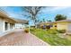 Beautiful backyard with brick pavers, lush landscaping, and water views from the covered patio at 179 Bath Club N Blvd, North Redington Beach, FL 33708