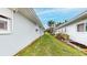 Exterior shot showcasing a well-maintained lawn and the home's clean lines against a backdrop of mature trees at 179 Bath Club N Blvd, North Redington Beach, FL 33708