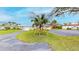 Charming front yard with a circular driveway, lush lawn, mature palm tree, and well-maintained landscaping at 179 Bath Club N Blvd, North Redington Beach, FL 33708