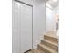 Hallway with hardwood floors, a staircase, and closet doors, offering a bright and airy feel at 2002 E Hanna Ave, Tampa, FL 33610