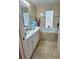 Well-lit bathroom featuring a large mirror, a soaking tub and tiled floor at 2114 W Hanna Ave, Tampa, FL 33604