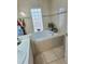 Inviting bathroom featuring a soaking tub, tiled surround and a single sink vanity at 2114 W Hanna Ave, Tampa, FL 33604