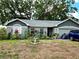 Charming single-story home featuring a well-kept lawn, two-car garage, and mature shade trees at 2114 W Hanna Ave, Tampa, FL 33604