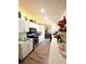 Spacious galley kitchen with white cabinets, stainless steel appliances, and laminate flooring at 2114 W Hanna Ave, Tampa, FL 33604