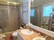 Functional bathroom featuring a double sink vanity, tiled shower with glass door, and built in storage at 301 1/2 Shore E Dr, Oldsmar, FL 34677