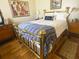 Bright bedroom featuring hardwood floors, vintage furniture, artwork, and a cozy brass bed at 301 1/2 Shore E Dr, Oldsmar, FL 34677