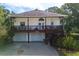 Charming two-story home featuring a wraparound porch, front-facing garages, and a beautifully landscaped yard at 301 1/2 Shore E Dr, Oldsmar, FL 34677