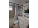 Clean bathroom featuring a tub with shower, a shelf, and a single sink vanity at 3302 Eisenhower Dr, Holiday, FL 34691