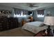 This bedroom has a ceiling fan, TV, dresser, and a bed with an elegant-patterned comforter at 3302 Eisenhower Dr, Holiday, FL 34691
