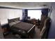 This bedroom has a large window, a full-sized bed, and is staged with shelves and a computer desk at 3302 Eisenhower Dr, Holiday, FL 34691