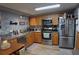 Functional kitchen featuring stainless steel appliances, wooden cabinetry, and ample counter space at 3302 Eisenhower Dr, Holiday, FL 34691