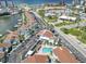 An aerial view of a coastal community with a pool, marina, and proximity to a beach and local amenities at 337 Rex Pl # E, Madeira Beach, FL 33708