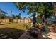 View of backyard with patio seating area, grass yard, and wooden fence for privacy at 4126 Carson Ne St, St Petersburg, FL 33703