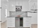 Stylish kitchen featuring white cabinets, a marble backsplash, and a sleek built-in wine cooler at 4395 50Th S Ter, St Petersburg, FL 33711