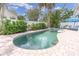 Backyard features a pool, spa, and seating area with mature landscaping at 4395 50Th S Ter, St Petersburg, FL 33711