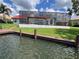 Waterfront home featuring a private dock, lush greenery, and a screened-in pool area, ideal for enjoying serene outdoor living at 4804 Longwater Way, Tampa, FL 33615