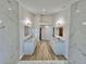 The airy bathroom features dual vanities, a walk-in shower, soaking tub, marble-look tile, and wood-look floors at 4804 Longwater Way, Tampa, FL 33615