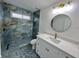 Modern bathroom with tiled shower, unique tile floors, and white vanity at 4804 Longwater Way, Tampa, FL 33615