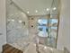 Walk-in shower and soaking tub area showcases marble-look tile, a window and hexagon tile flooring at 4804 Longwater Way, Tampa, FL 33615